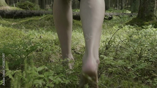 girl walks barefoot in the woods in a cloak