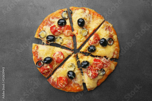 Sliced delicious pizza on gray background