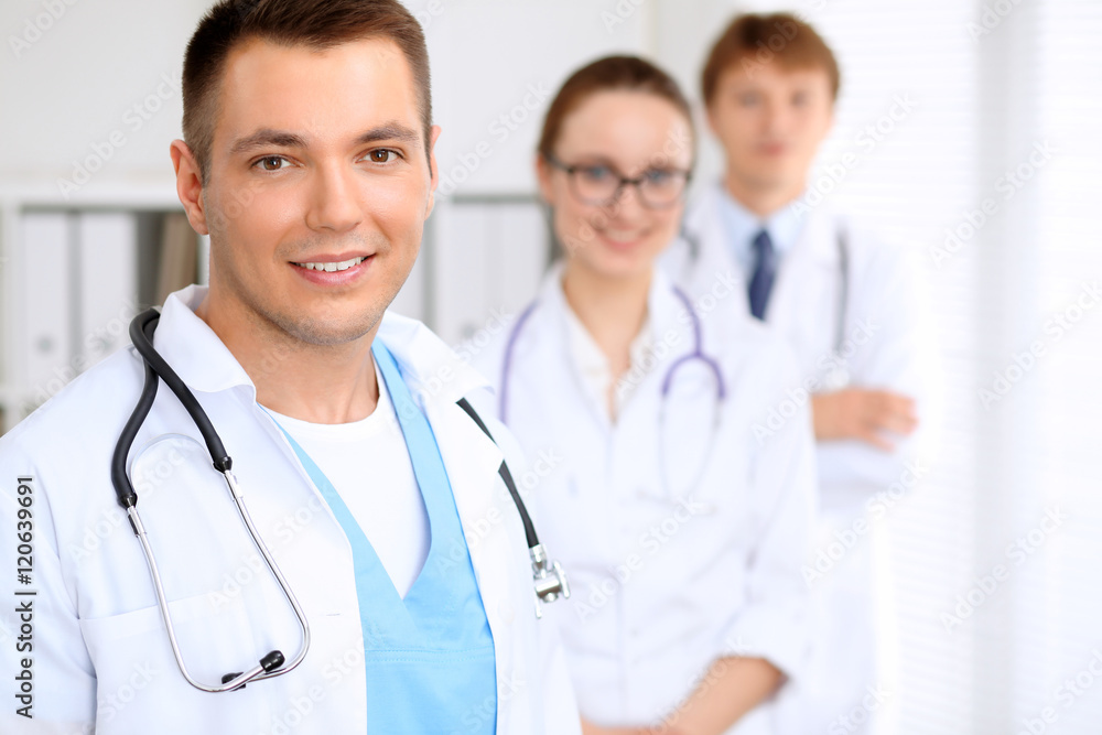 Cheerful smiling male doctor with medical staff at the hospital Cheerful smiling male doctor with medical staff at the hospital