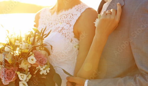 Groom and bride hugging, ou...