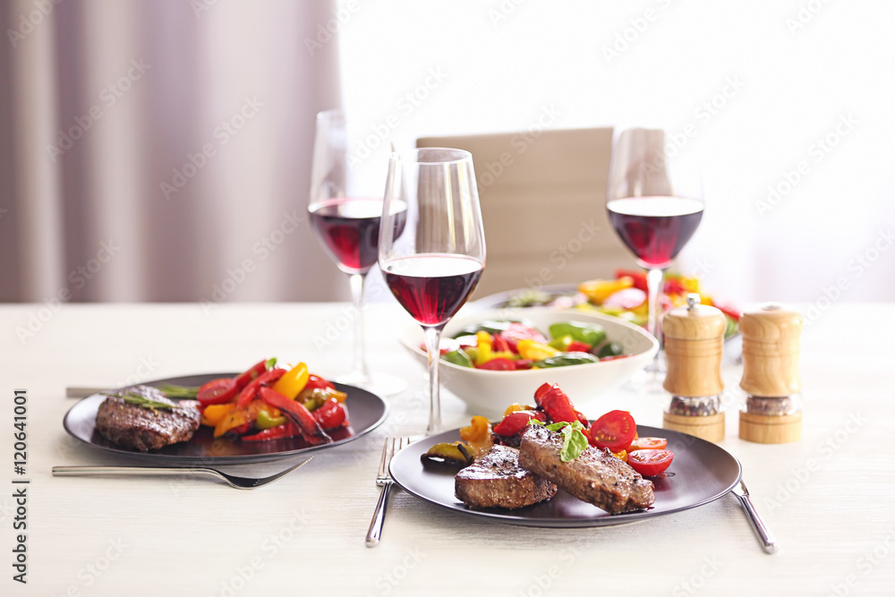 Tasty steak with fried vegetables on dinner table Tasty steak with fried vegetables on dinner table