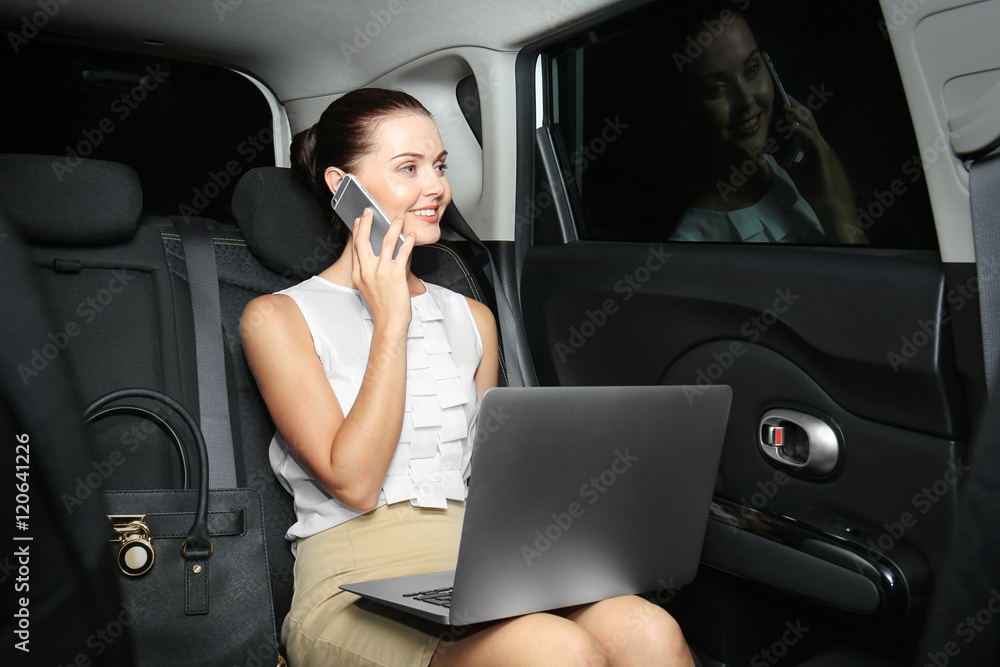Beautiful business woman sitting in back seat of car Beautiful business woman sitting in back seat of car
