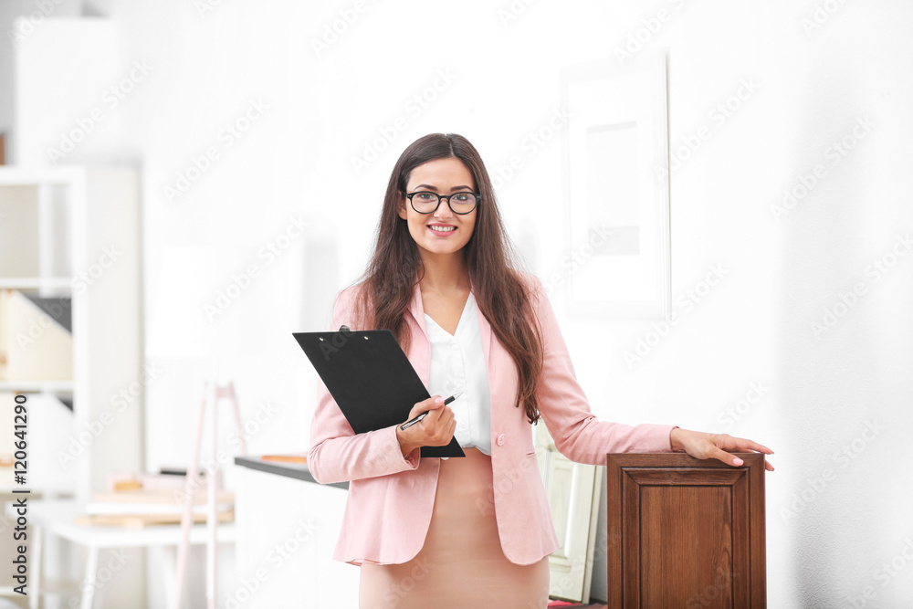 Beautiful female designer with wooden sample in office Beautiful female designer with wooden sample in office