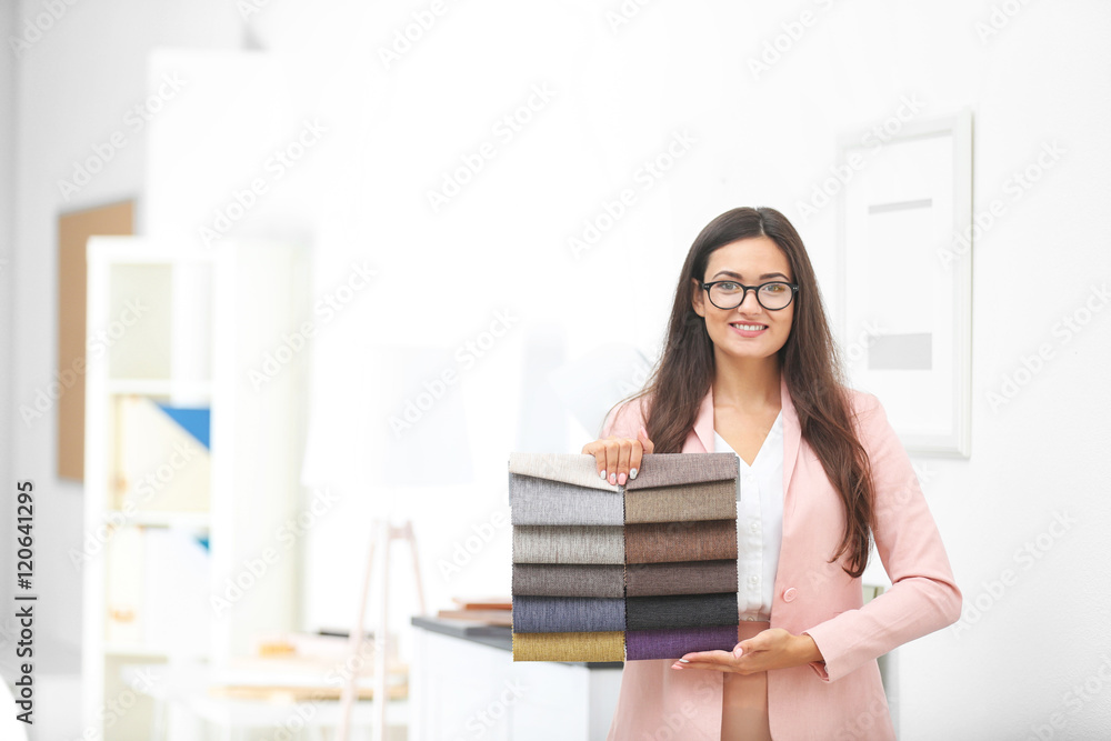 Beautiful female designer with textile swatches in office Beautiful female designer with textile swatches in office