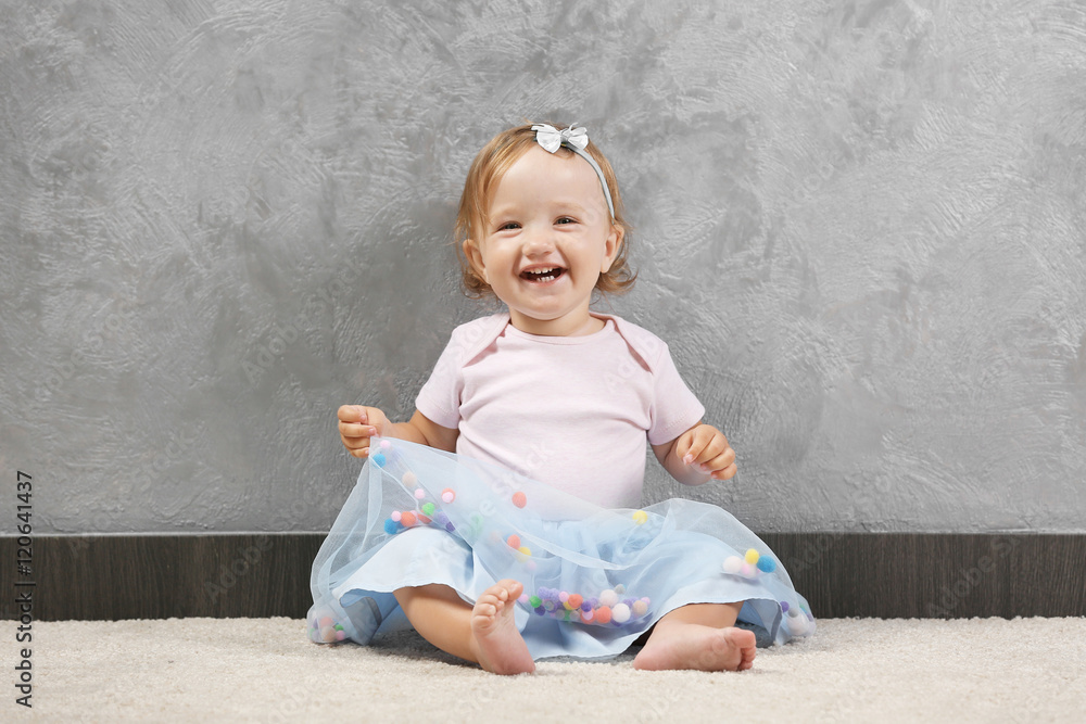 Fototapeta premium Little fashion-girl posing on a gray wall background