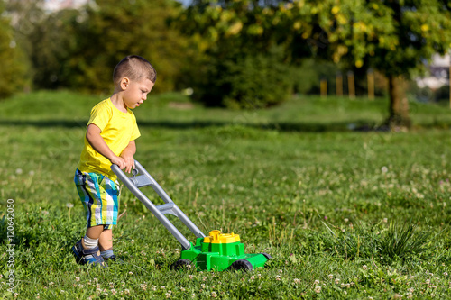 child mowing grass
