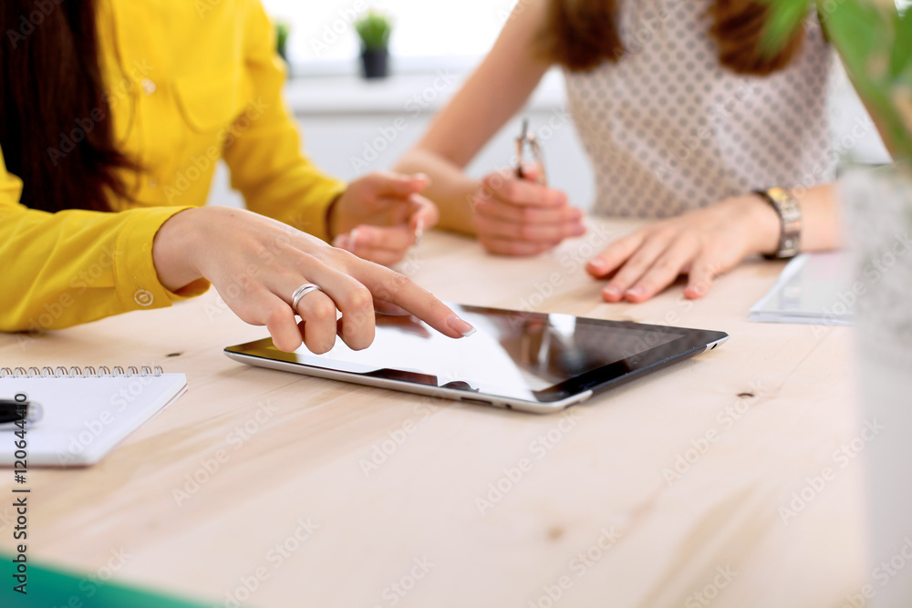 Two business woman or friends are talking and using tablet computer Two business woman or friends are talking and using tablet computer