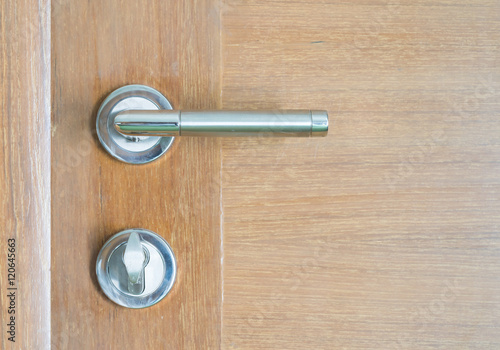 Silver metal door handle and brown wood door