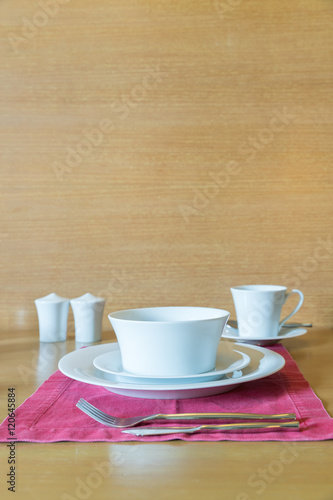 Set of white plate and table setting in hotel room