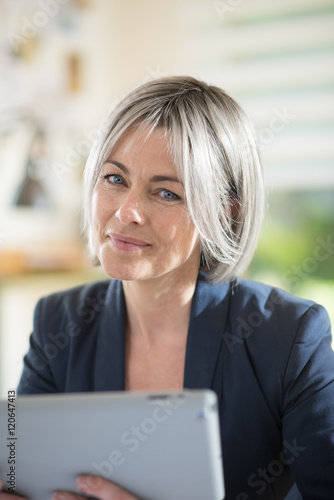 Portrait of a gray haired businesswoman using a tablet Free Download Portrait of a gray haired businesswoman using a tablet - GFXLoad