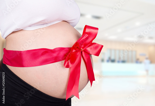 Wallpaper Mural close up pregnant woman with red ribbon gift on belly in hospita Torontodigital.ca