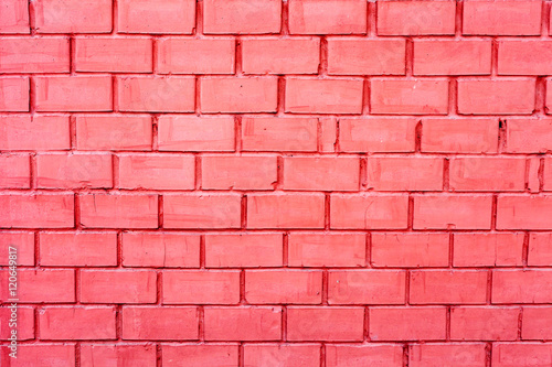 Brick wall made of bricks painted in pink. The texture of a brick wall. The horizontal masonry. Texture as background with a copy of the space.