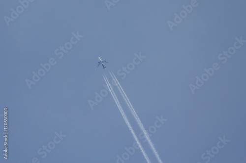Airplane in the blue sky with condensation trail