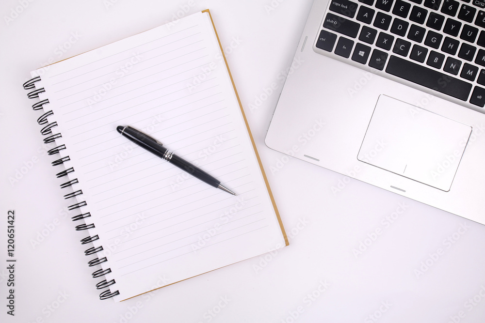 Pen on notebook with laptop Pen on notebook with laptop
