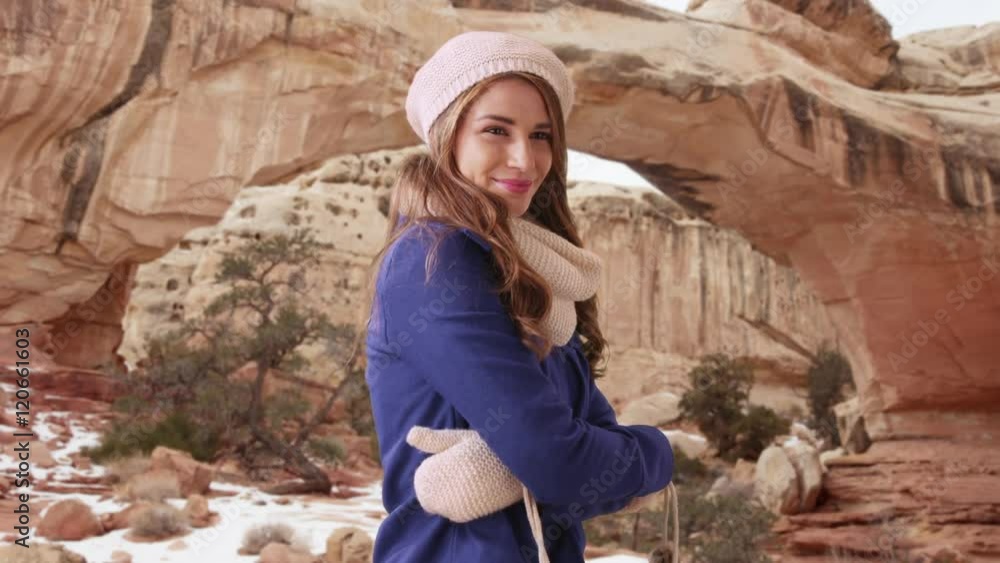 Portrait of woman wearing winter clothing and smiling at camera. Standing in the snow in the mountains staying warm Portrait of woman wearing winter clothing and smiling at camera. Standing in the snow in the mountains staying warm