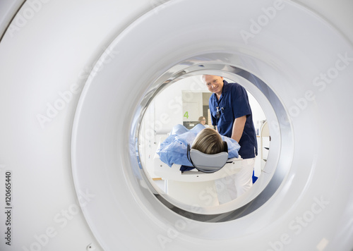 Male Doctor Looking At Patient Undergoing CT Scan photo