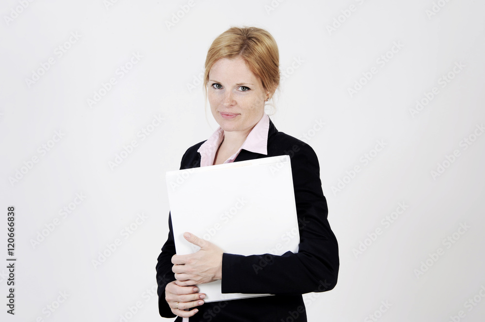 Young freckled businesswoman is standing with a portfolio, looking into the camera with an elegance smile. Studio shot with light background. Isolated. Young freckled businesswoman is standing with a portfolio, looking into the camera with an elegance smile. Studio shot with light background. Isolated.
