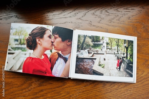Open pages of album photobook couple in love on wooden background photo