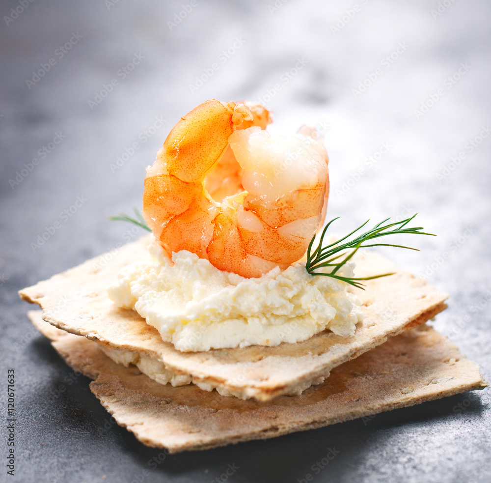 Appetizer canape with shrimp, cheese and dill on a small loaf of bread, closeup . Appetizer canape with shrimp, cheese and dill on a small loaf of bread, closeup .