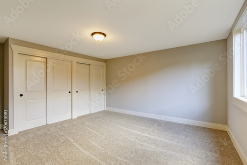 Empty room interior with blue tones walls and carpet floor.