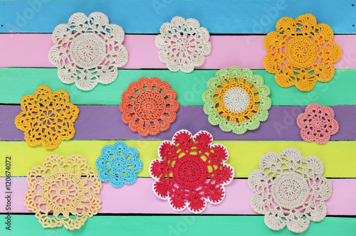 The wonderful  crochet doilies on colourful wooden table