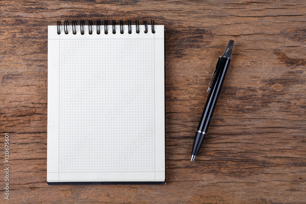 Blank note pad with pen on wood background Blank note pad with pen on wood background