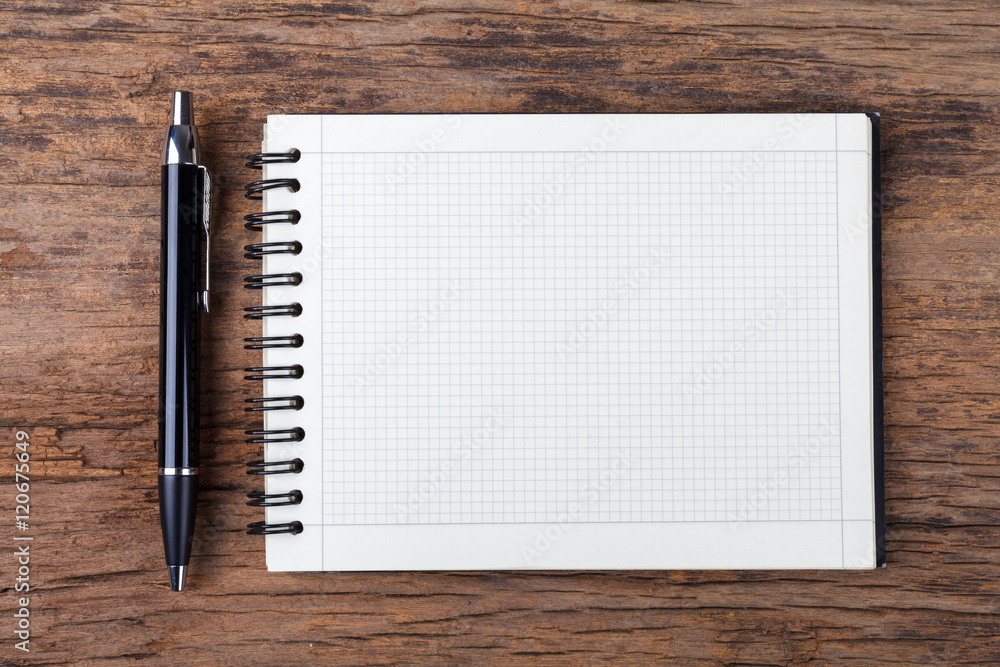 Blank note pad with pen on wood background.. Blank note pad with pen on wood background..