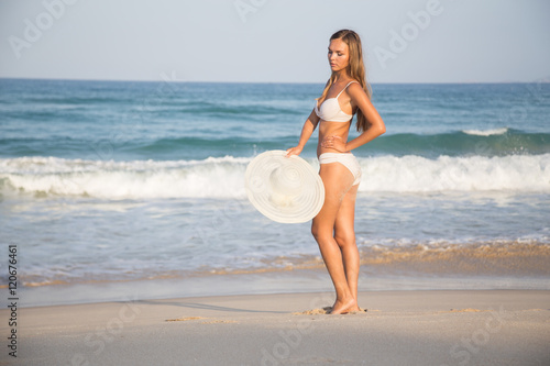 girl on the beach in a white hat in travel vacation ocean