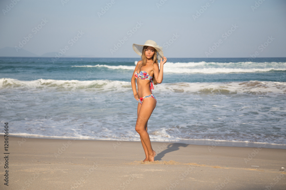 girl on the beach in a white hat in travel vacation ocean