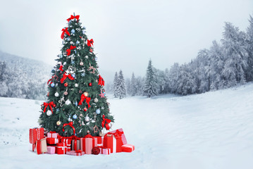 Decorated Christmas tree with gifts on nature background. Christmas holiday concept.