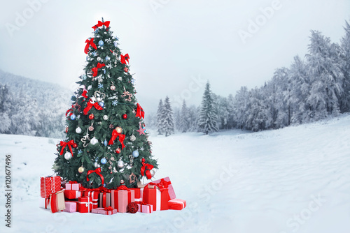 Decorated Christmas tree with gifts on nature background. Christmas holiday concept.