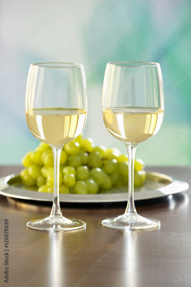 Glasses with white wine and grape on a table Glasses with white wine and grape on a table