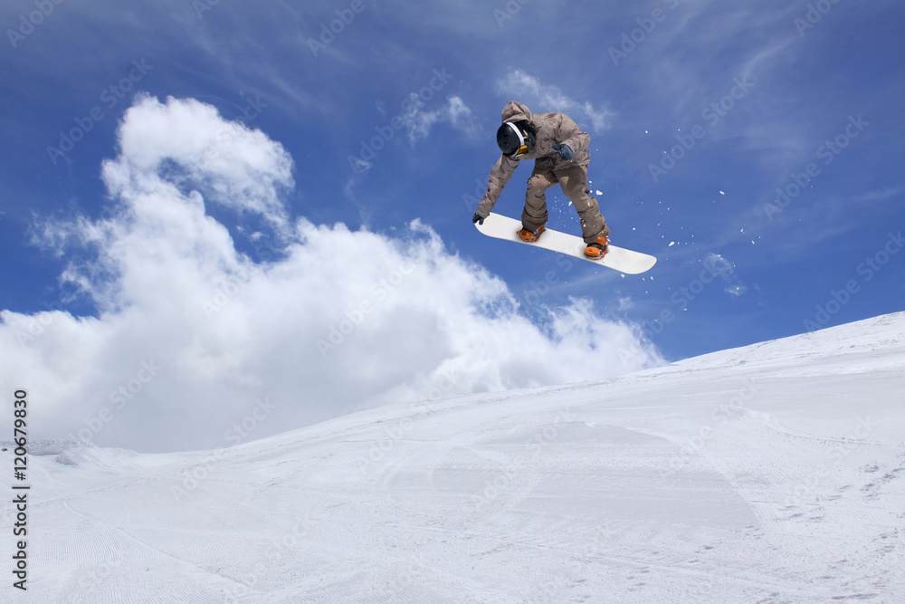 Snowboarder jumping in snowy winter mountains