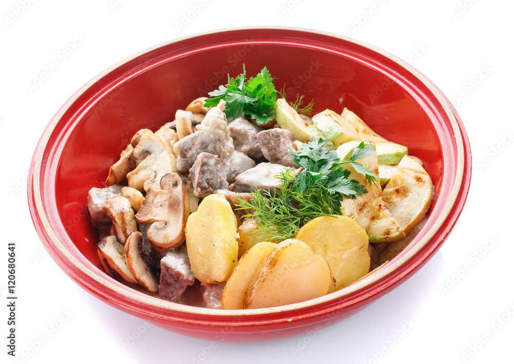 meat with mushrooms and vegetables in a pot on white meat with mushrooms and vegetables in a pot on white