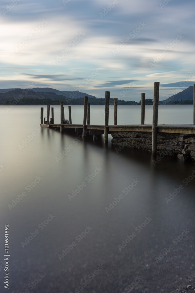 Wooden Jetty with poles leading into Derwentwater Lake in the Lake District, UK.