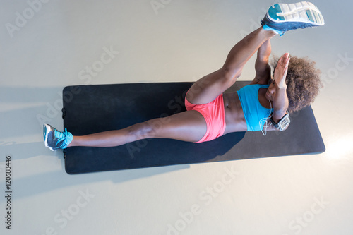 Top view of beautiful Afro American sportswoman doing abs while