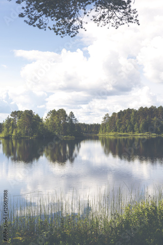 Beautiful summer day at the lake. Reflective water.  Image has a vintage effect applied.