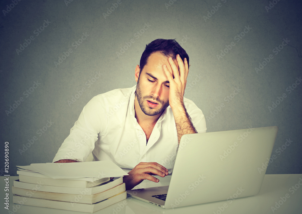tired sleepy man sitting at desk with books laptop computer tired sleepy man sitting at desk with books laptop computer