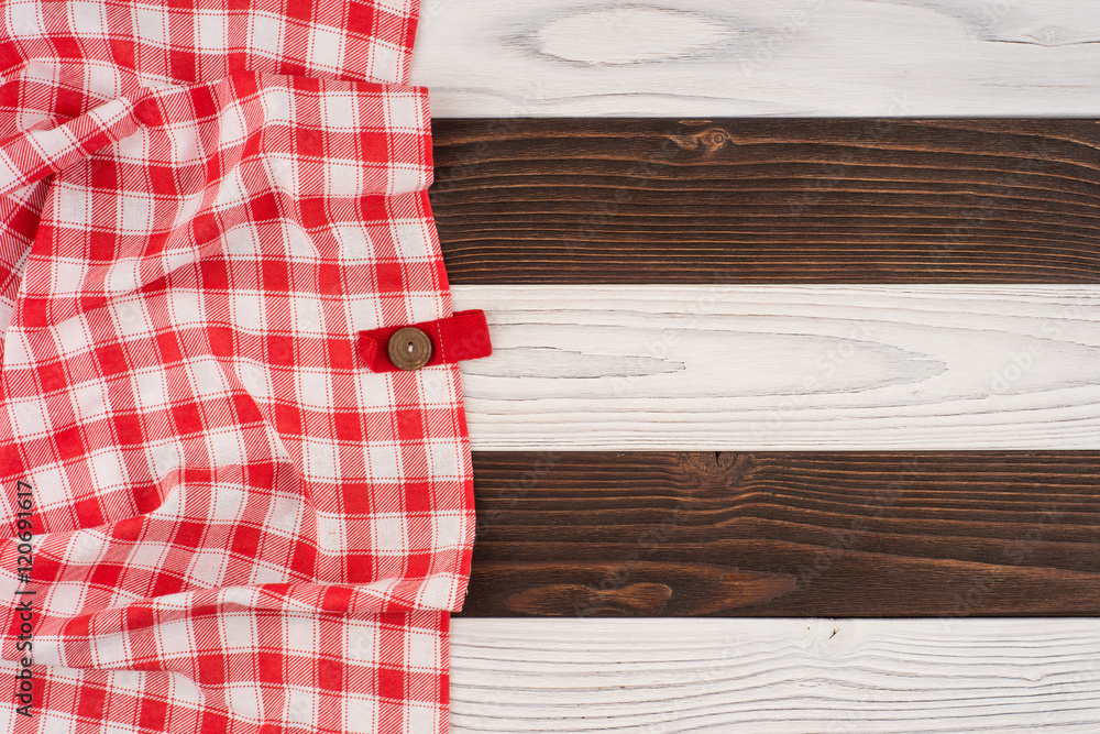 Obraz premium red folded tablecloth over wooden table.