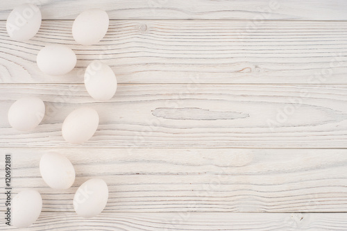 Chicken eggs on white old wooden table.