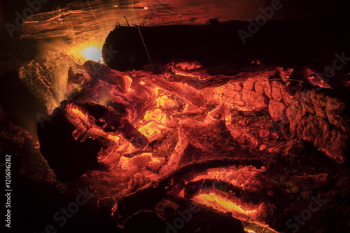 Hot coals in a camp fire at night