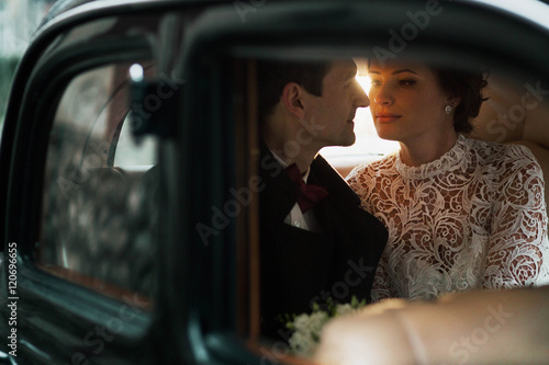 young and beautiful couple sitting in the wedding cortege