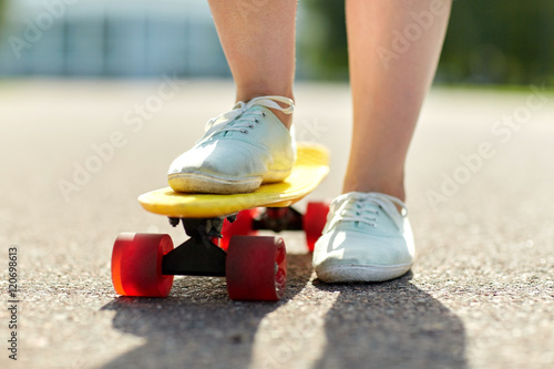 close up of female feet riding short skateboard