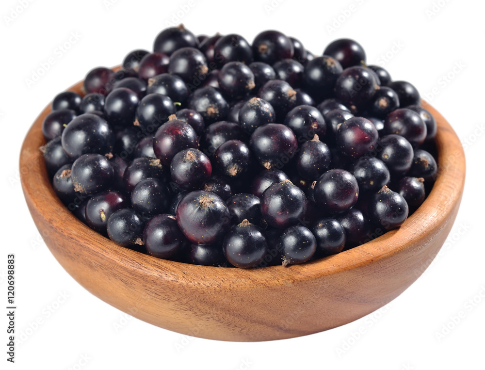 Fresh black currant in a wooden bowl on a white