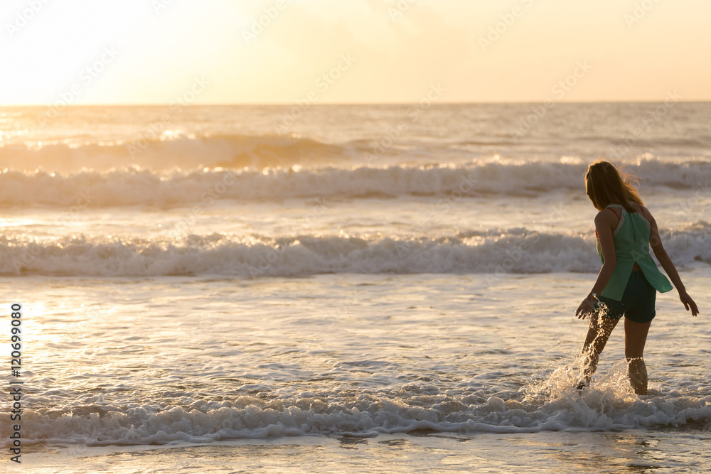 woman walking on the beach, sunshine in the morning summer sea woman walking on the beach, sunshine in the morning summer sea