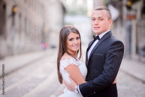 Beautiful stylish newlyweds posing in old town