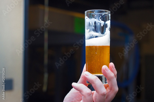 Belgian lambic (geuze) beer glass in hand. photo