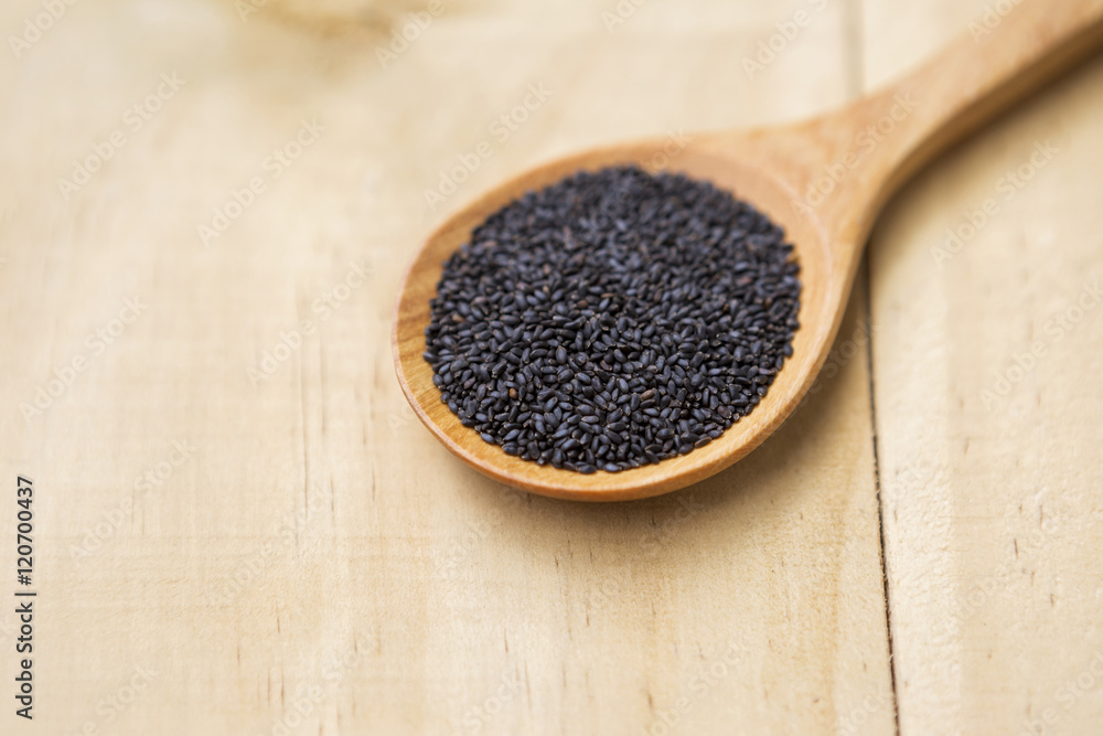 Black sweet basil seed on wooden spoon Black sweet basil seed on wooden spoon