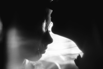 silhouettes heads of the bride and groom in darkness