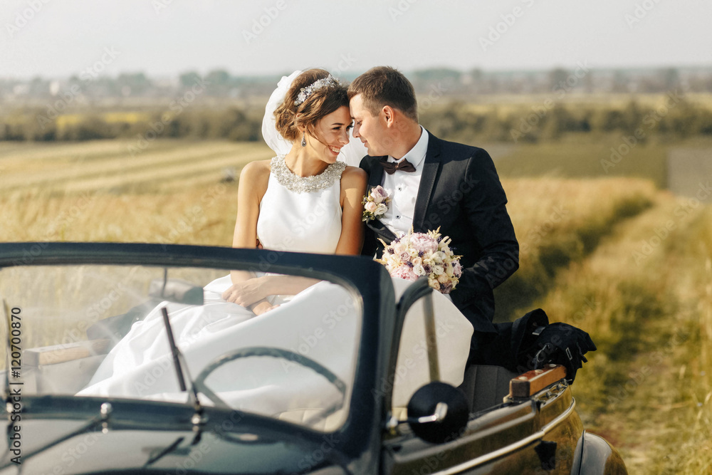 beautiful and happy husband and wife sitting in a car